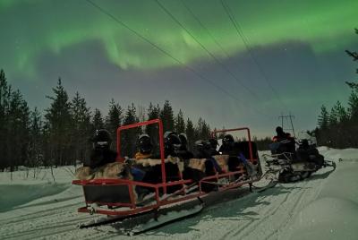 Trineo de auroras boreales en moto de nieve